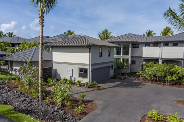 73-4804 Hinahina Rd Unit 13, Kailua-Kona, HI 96740 - view of property exterior with metal roof, a standing seam roof, concrete driveway, an attached garage, and stucco siding
