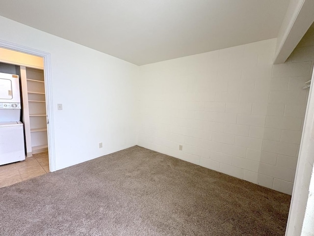 4156 Rice St Unit 404, Lihue, HI 96766 - unfurnished bedroom featuring stacked washer / drying machine, light colored carpet, and concrete block wall