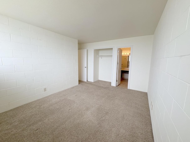 4156 Rice St Unit 404, Lihue, HI 96766 - unfurnished bedroom with concrete block wall, light colored carpet, a closet, and ensuite bathroom