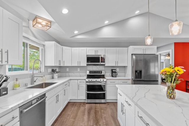 15-1884 14th Ave, Keaau, HI 96749 - kitchen featuring appliances with stainless steel finishes, a sink, lofted ceiling, white cabinets, and wood finished floors