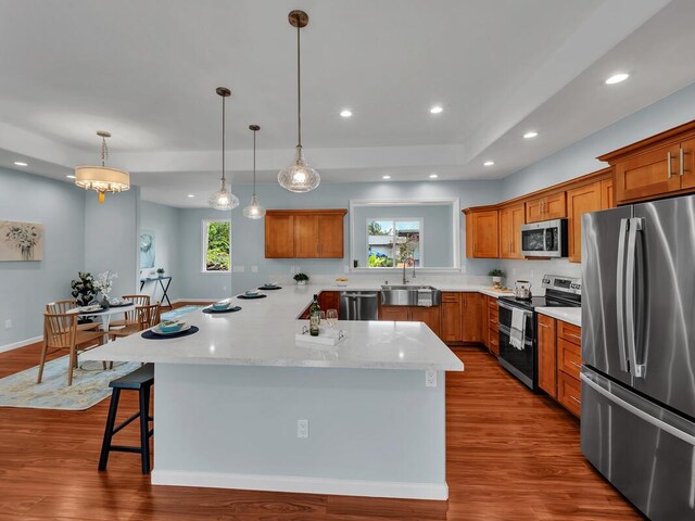 15-1047 Pilikai Rd, Keaau, HI 96749 - kitchen featuring stainless steel appliances, a sink, brown cabinets, a kitchen bar, and recessed lighting