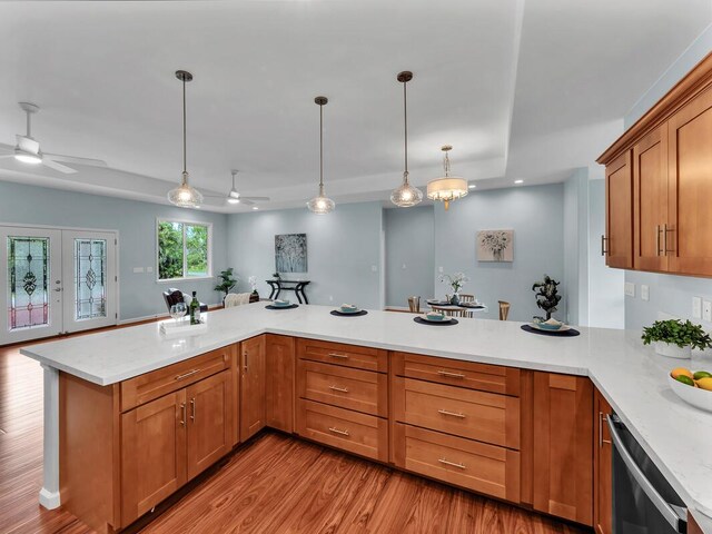 15-1047 Pilikai Rd, Keaau, HI 96749 - kitchen with ceiling fan, a peninsula, light wood-style flooring, pendant lighting, and brown cabinets