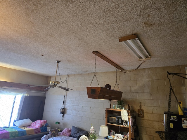 355 Kalanianaole Ave Unit 103, Hilo, HI 96720 - garage view of ceiling fan, a textured ceiling, black microwave, and concrete block wall
