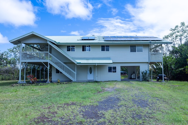 15-1517 7th Ave, Keaau, HI 96749 - back of house featuring a carport, stairway, roof mounted solar panels, dirt driveway, and a yard