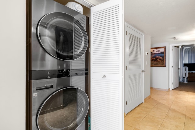 75-6106 Alii Dr Unit 208, Kailua-Kona, HI 96740 - laundry room featuring stacked washer / drying machine, baseboards, and tile patterned flooring
