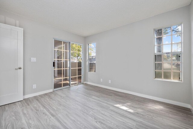 68-3890 Lua Kula St Unit 1104, Waikoloa, HI 96738 - unfurnished room with wood finished floors, plenty of natural light, a textured ceiling, and baseboards