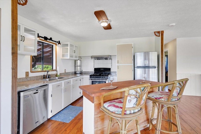 12-138 Oliana Dr, Pahoa, HI 96778 - kitchen with stainless steel appliances, light wood-type flooring, extractor fan, light countertops, and a sink