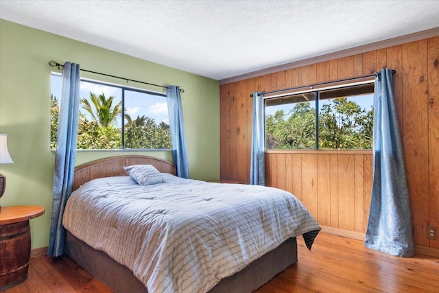 12-138 Oliana Dr, Pahoa, HI 96778 - bedroom featuring hardwood / wood-style floors, multiple windows, baseboards, and wooden walls