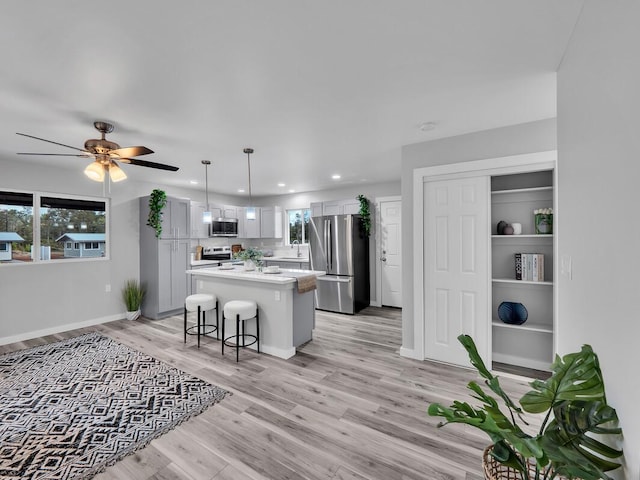 11-3063-A Puolani St, Volcano, HI 96785 - kitchen featuring appliances with stainless steel finishes, a center island, light countertops, a sink, and light wood-style floors