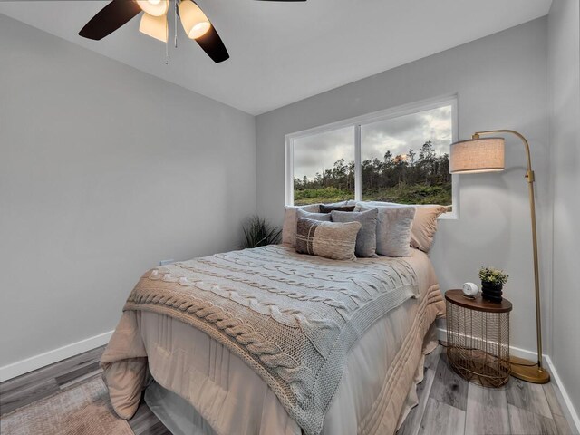 11-3063-A Puolani St, Volcano, HI 96785 - bedroom with baseboards, wood finished floors, and ceiling fan