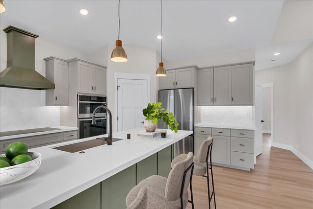 15-1616 7th Ave, Keaau, HI 96749 - kitchen featuring wall chimney range hood, gray cabinetry, decorative backsplash, stainless steel appliances, and lofted ceiling