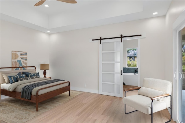 15-1616 7th Ave, Keaau, HI 96749 - bedroom featuring a barn door, wood finished floors, multiple windows, a tray ceiling, and recessed lighting