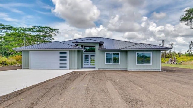 15-1616 7th Ave, Keaau, HI 96749 - view of front facade with board and batten siding, driveway, an attached garage, and metal roof