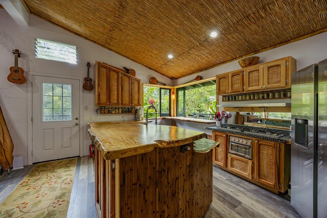 14-3401 Pakalana Rd, Pahoa, HI 96778 - kitchen with lofted ceiling, stainless steel refrigerator with ice dispenser, wood ceiling, light wood-style floors, and plenty of natural light