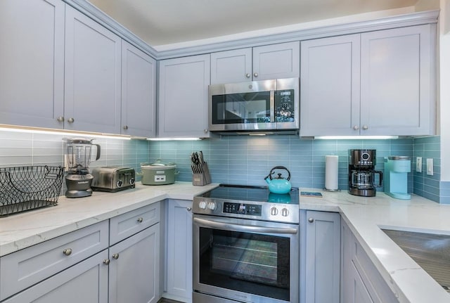 5300 Ka Haku Rd Unit 1, Princeville, HI 96722 - kitchen featuring appliances with stainless steel finishes, decorative backsplash, and light stone countertops