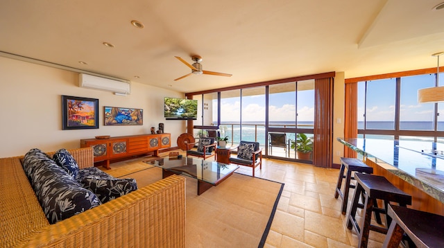 5050 Lawai Rd Unit 413, Koloa, HI 96756 - living room featuring a wall mounted air conditioner, floor to ceiling windows, stone tile floors, and a ceiling fan