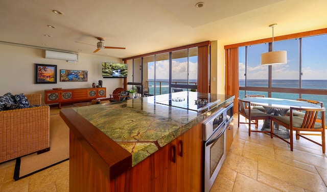 5050 Lawai Rd Unit 413, Koloa, HI 96756 - kitchen with oven, a center island, ceiling fan, black electric stovetop, and tile countertops