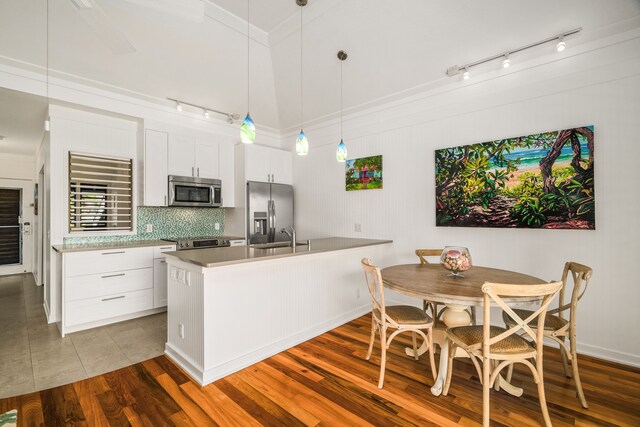 2253 Poipu Rd Unit 162, Koloa, HI 96756 - kitchen with stainless steel appliances, rail lighting, decorative backsplash, a peninsula, and white cabinets