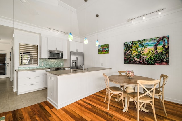 2253 Poipu Rd Unit 162, Koloa, HI 96756 - kitchen featuring stainless steel appliances, track lighting, tasteful backsplash, a peninsula, and hanging light fixtures