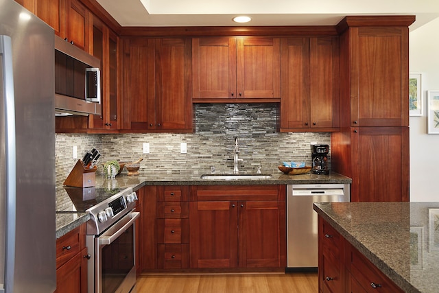 2611 Kiahuna Plantation Dr Unit 13B, Koloa, HI 96756 - kitchen with stainless steel appliances, a sink, tasteful backsplash, dark stone counters, and light wood finished floors