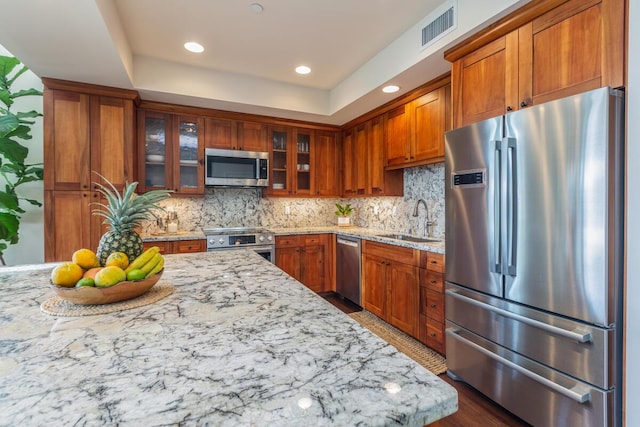 2611 Kiahuna Plantation Dr Unit 4G, Koloa, HI 96756 - kitchen with appliances with stainless steel finishes, a sink, brown cabinetry, light stone counters, and recessed lighting