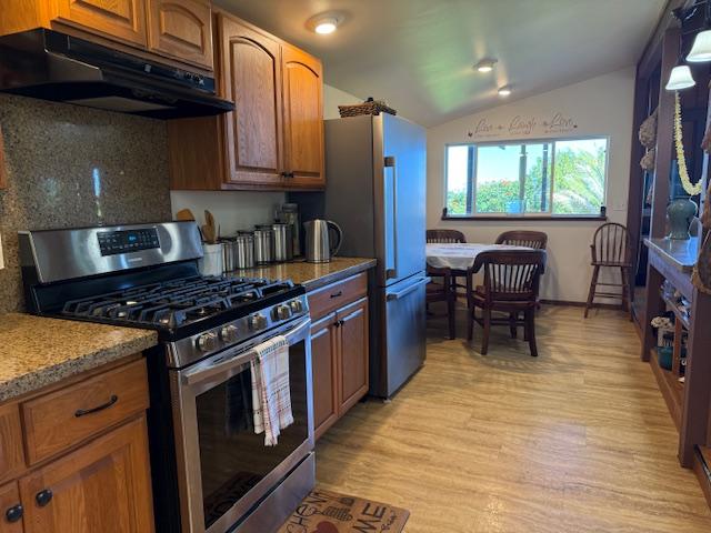 48-5441 Kukuihaele Rd, Honokaa, HI 96727 - kitchen featuring gas range, under cabinet range hood, fridge, backsplash, and brown cabinets