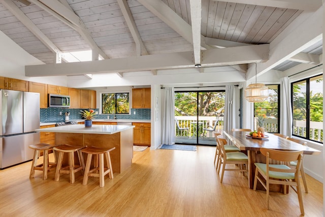 4160 Kalani Pl, Princeville, HI 96722 - kitchen with appliances with stainless steel finishes, a center island, light wood-style flooring, light countertops, and tasteful backsplash