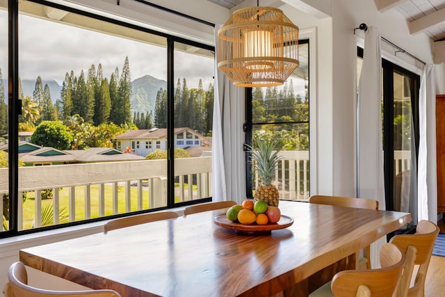 4160 Kalani Pl, Princeville, HI 96722 - dining area with healthy amount of natural light, beam ceiling, a mountain view, and wood finished floors