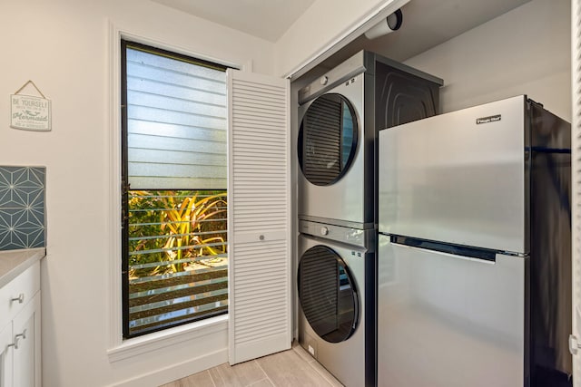4160 Kalani Pl, Princeville, HI 96722 - laundry area with stacked washer and clothes dryer, plenty of natural light, and light wood-style floors