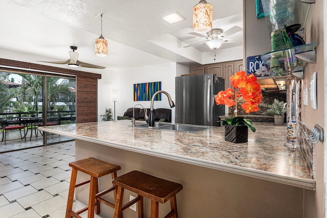 75-6082 Alii Dr Unit B229, Kailua-Kona, HI 96740 - kitchen featuring ceiling fan, freestanding refrigerator, a sink, a peninsula, and pendant lighting