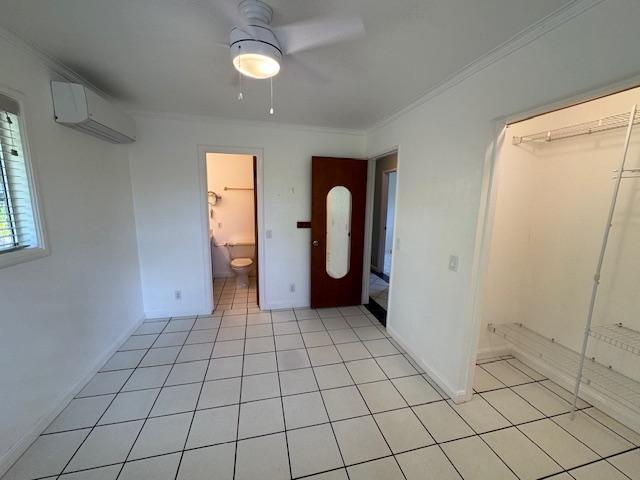 1681 Papau St, Kapaa, HI 96746 - unfurnished bedroom with an AC wall unit, crown molding, light tile patterned flooring, a ceiling fan, and baseboards