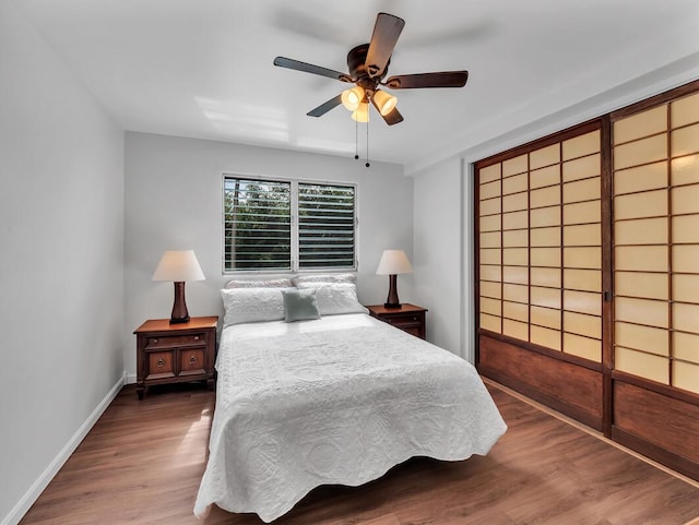 75-5766 Kuakini Hwy Unit 101, Kailua-Kona, HI 96740 - bedroom with wood finished floors, baseboards, and ceiling fan
