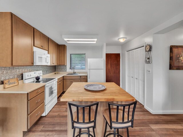 75-5766 Kuakini Hwy Unit 101, Kailua-Kona, HI 96740 - kitchen with white appliances, a sink, a kitchen breakfast bar, dark wood finished floors, and backsplash