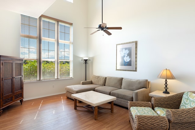 69-555 Waikoloa Beach Dr Unit 1704, Waikoloa, HI 96738 - living area with light wood-type flooring, baseboards, ceiling fan, and a high ceiling