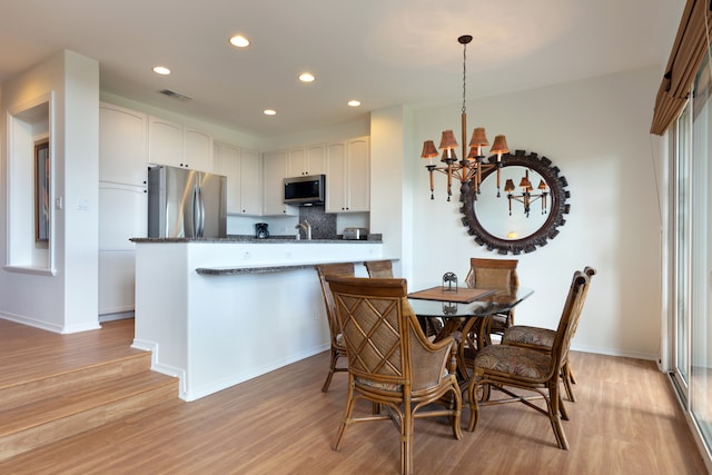 69-555 Waikoloa Beach Dr Unit 1704, Waikoloa, HI 96738 - dining space featuring a chandelier, light wood-style flooring, recessed lighting, and baseboards