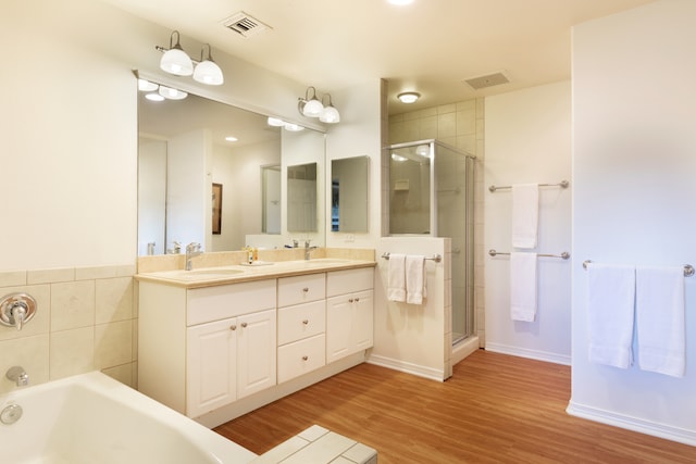 69-555 Waikoloa Beach Dr Unit 1704, Waikoloa, HI 96738 - full bathroom featuring a stall shower, double vanity, a garden tub, and wood finished floors