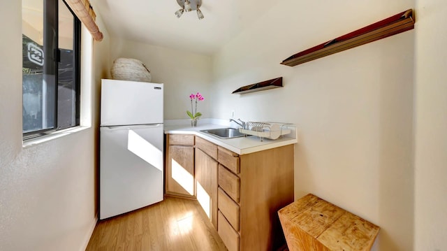 4740 Lae Rd, Kalaheo, HI 96741 - kitchen with freestanding refrigerator, a sink, light wood-style floors, and light countertops