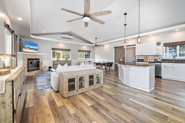 71-1876 Puu Lani Loop, Kailua-Kona, HI 96740 - living area with a barn door, a ceiling fan, recessed lighting, a wall mounted air conditioner, and light wood-style floors