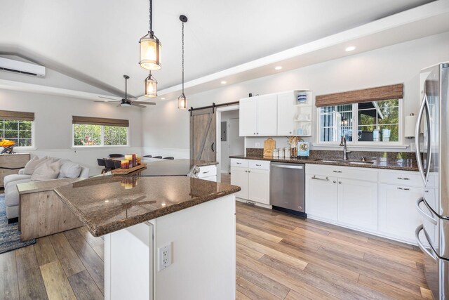 71-1876 Puu Lani Loop, Kailua-Kona, HI 96740 - kitchen featuring appliances with stainless steel finishes, a sink, a barn door, light wood-style floors, and open floor plan