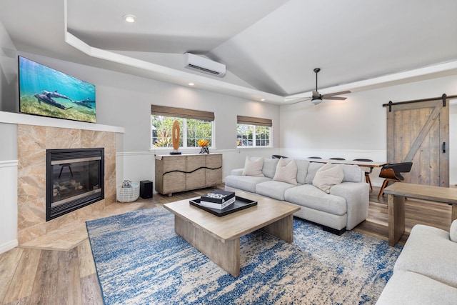 71-1876 Puu Lani Loop, Kailua-Kona, HI 96740 - living room with a barn door, wood finished floors, a wall mounted air conditioner, lofted ceiling, and ceiling fan