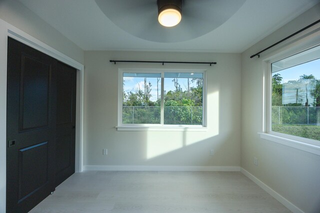 16-2100 Silveroak Dr, Pahoa, HI 96778 - unfurnished bedroom featuring multiple windows, light wood-style floors, and baseboards