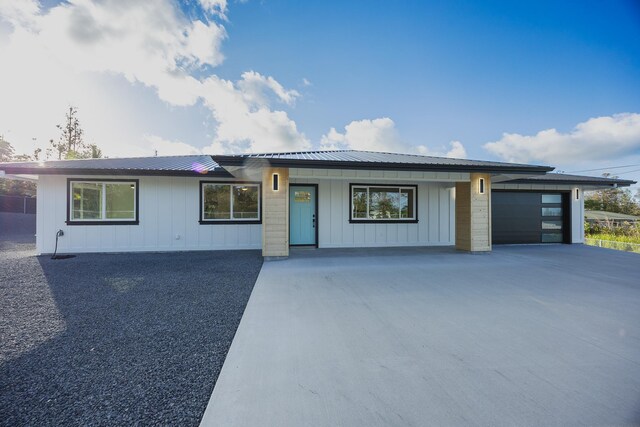 16-2100 Silveroak Dr, Pahoa, HI 96778 - view of front of property with driveway, board and batten siding, metal roof, and an attached garage