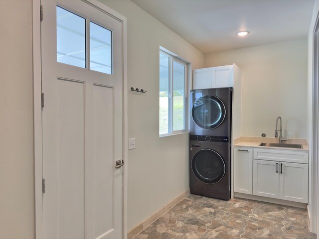 94-5763 Awa Pae Pl, Naalehu, HI 96772 - laundry room with stacked washer / drying machine, cabinet space, baseboards, light stone finish flooring, and recessed lighting