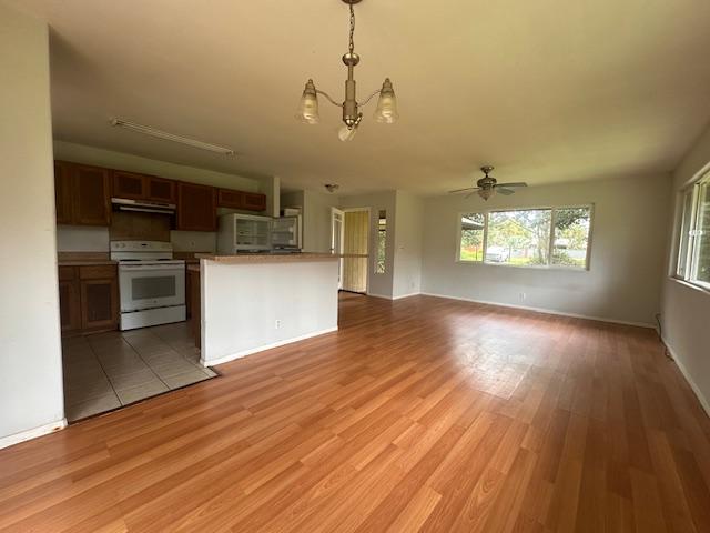 15-1415 14th Ave, Keaau, HI 96749 - kitchen with white range with electric cooktop, range hood, a chandelier, and plenty of natural light