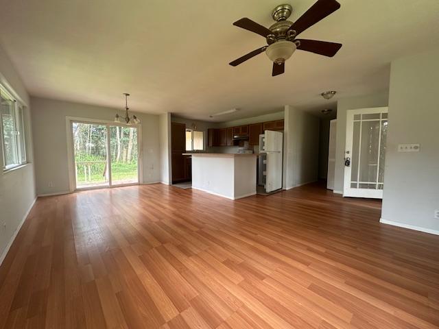 15-1415 14th Ave, Keaau, HI 96749 - unfurnished living room with a chandelier, light wood-style floors, baseboards, and ceiling fan
