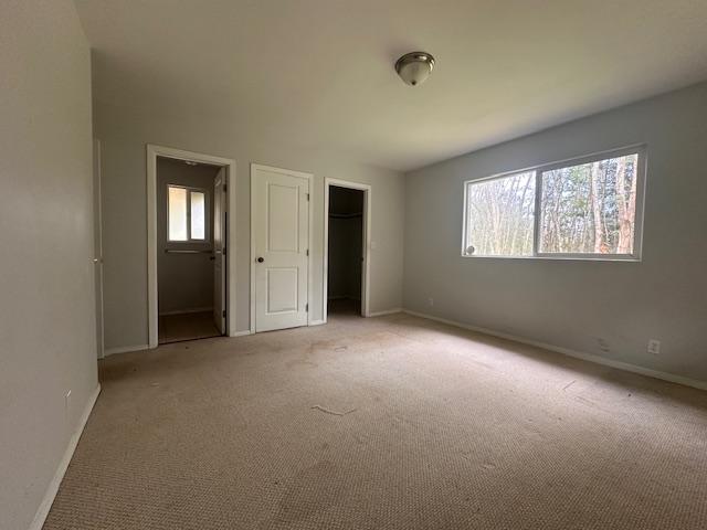 15-1415 14th Ave, Keaau, HI 96749 - unfurnished bedroom with baseboards, light carpet, and a closet