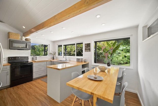 2-3161 Kaumualii Hwy Unit 2, Kalaheo, HI 96741 - kitchen with black / electric stove, stainless steel microwave, a sink, a peninsula, and light wood-style floors