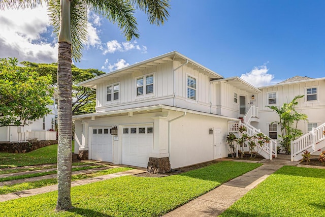 4771 Pepelani Lp Unit 921, Princeville, HI 96722 - view of front of house featuring an attached garage, board and batten siding, a front yard, and stairway