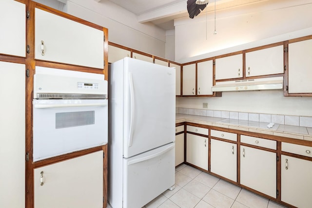 81-6267 Piko Rd, Captain Cook, HI 96704 - kitchen with white appliances, under cabinet range hood, light tile patterned floors, beamed ceiling, and tile counters