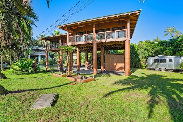 5-7084 Kuhio Hwy, Hanalei, HI 96714 - rear view of house with a wooden deck, stairway, a lawn, a garden, and board and batten siding